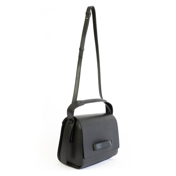 Black eco vegan leather barrel shoulder bag by Sydney Brown. Timeless, classic and modern. Angle Front view shoulder strap